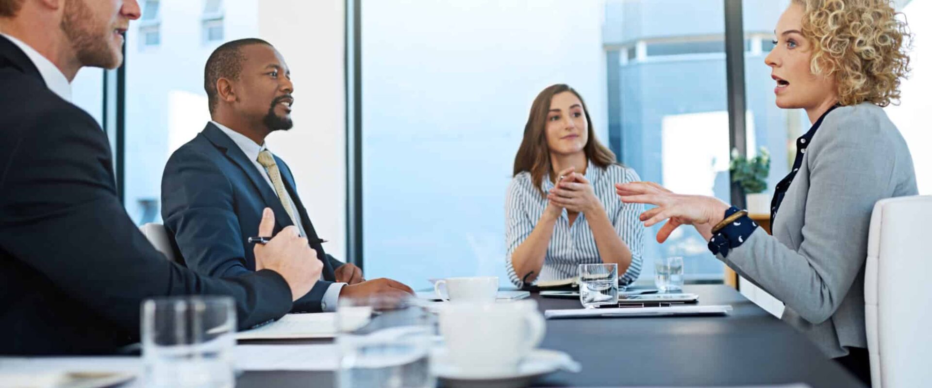 Business, group and talking in boardroom for meeting at company, ideas or planning. Team, people and office with strategy or brainstorming for pitch, corporate leadership in New York City or USA.